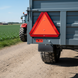 Triunghi reflectorizant roșu montat pe remorca tractorului agricol în mediu rural 